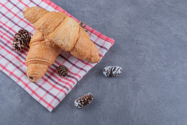 Two freshly baked Fresh croissant on grey background.