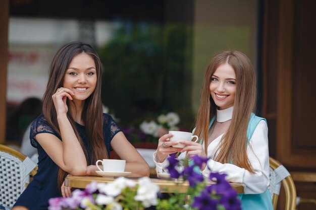 Two friends in cafe with coffee and mobile phone