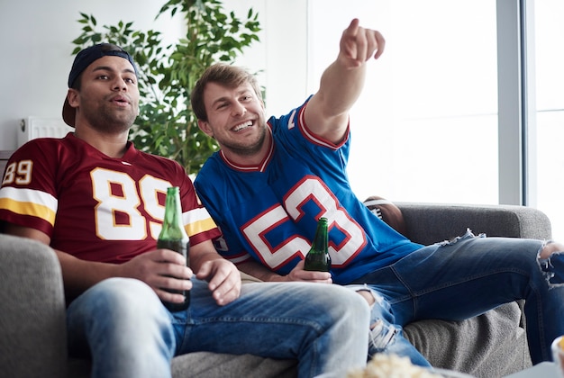 Two friends cheering at home