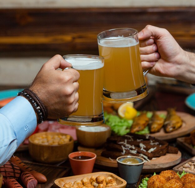 two friends clinking beer mugs in beer setup