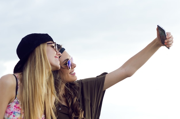 Two friends doing sefie on smart phone