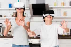 Free photo two friends at home having fun with virtual reality headset