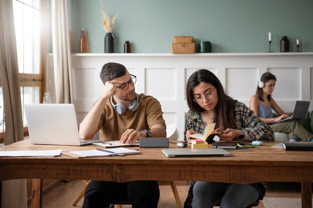 Two friends reading from a book during study session