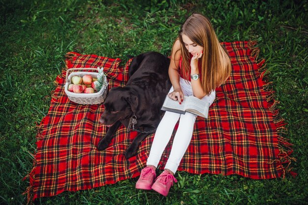 Two friends sitting on the blanket carped in the park