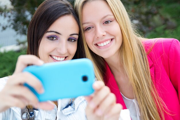 スマートフォンで写真を撮っている2人の友人