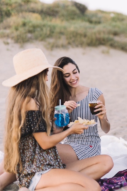 Two friends with drinks at the beach