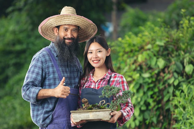 植物の鍋を持って笑っている2人の庭師