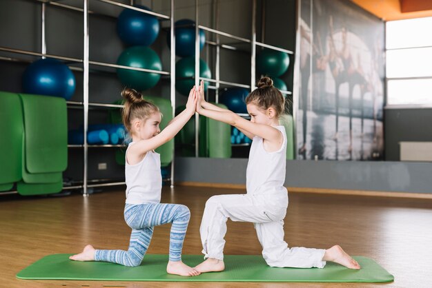 Два девочки, тренирующиеся вместе в спортзале