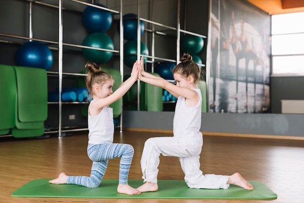 Two girl child exercising together at gym