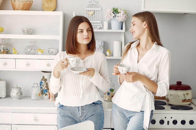 Two girlfriends drinking tea at home