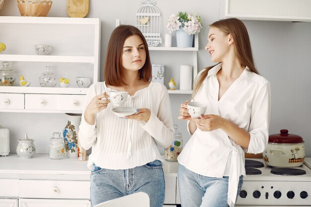 Две подруги пьют чай дома