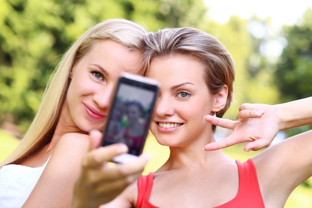 Two girls are taking photos of themselves