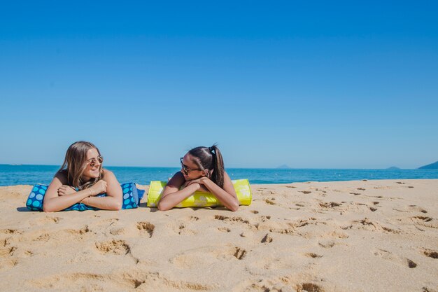 Two girls at the beach talking