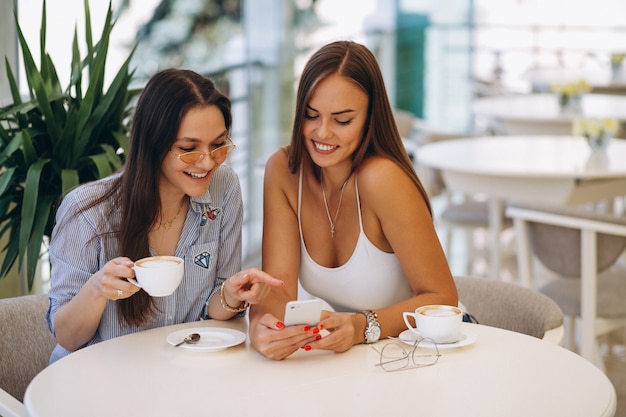 Two girls at cafe having tea