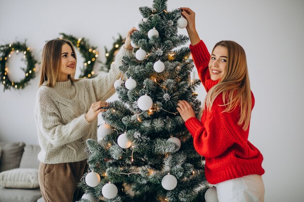 Two girls decorating christmas tree