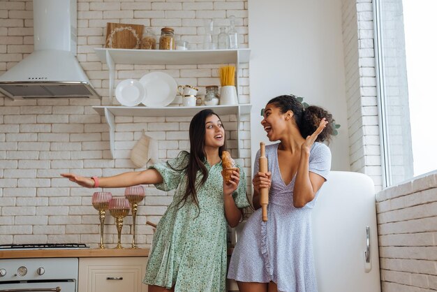 Two girls of different races having fun in the kitchen