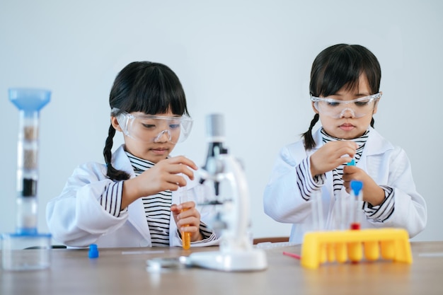 Due ragazze che fanno esperimenti scientifici in un laboratorio. messa a fuoco selettiva.