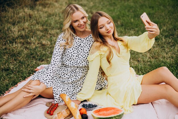 Two girls friends having picnic in park