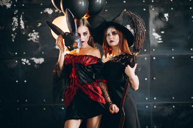 Free photo two girls in halloween costumes