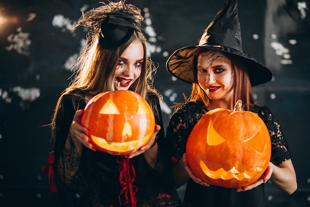 Free photo two girls in halloween costumes