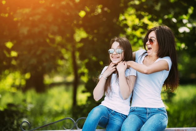 Two girls having fun sitting in park