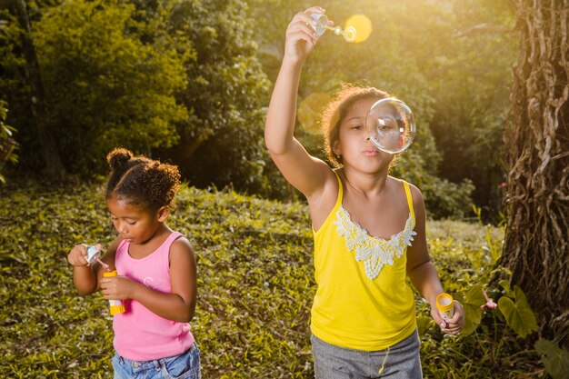 Two girls making soap bubbles