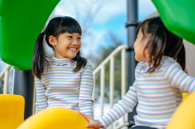 Free photo two girls play slides in the playground. selective focus