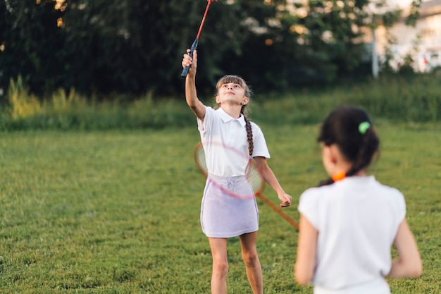 Two girls playing badminton in the park