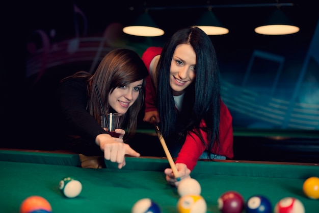 Free photo two girls playing pool game