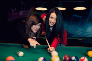 Two girls playing pool game