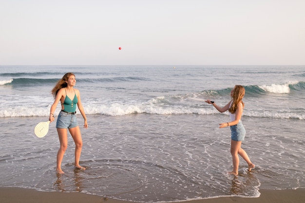 Two girls playing tennis at seashore