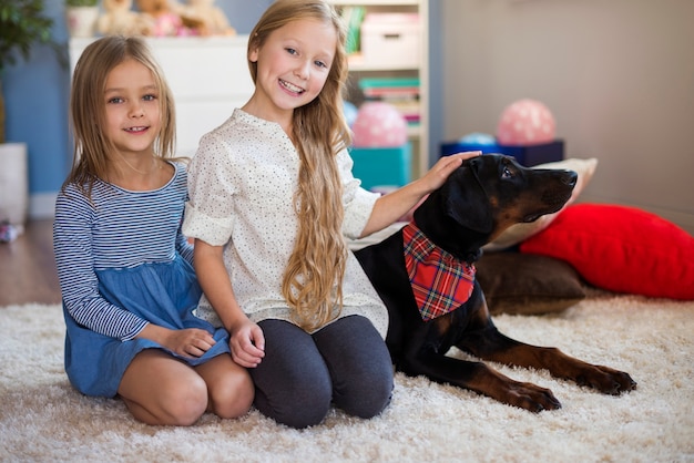 Free photo two girls posing with their beloved pet