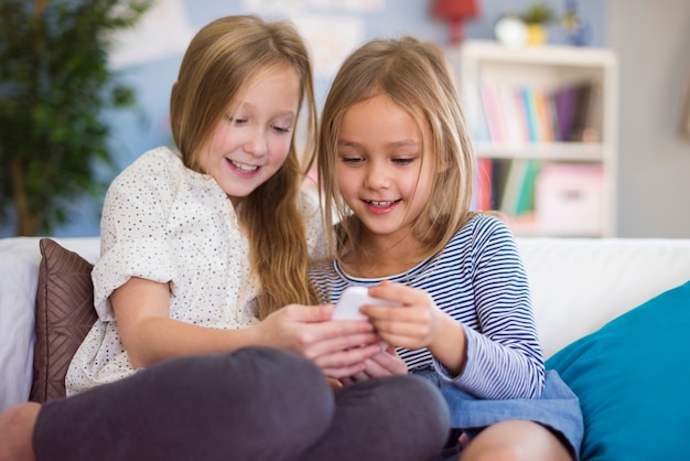 Free photo two girls reading funny message from friend