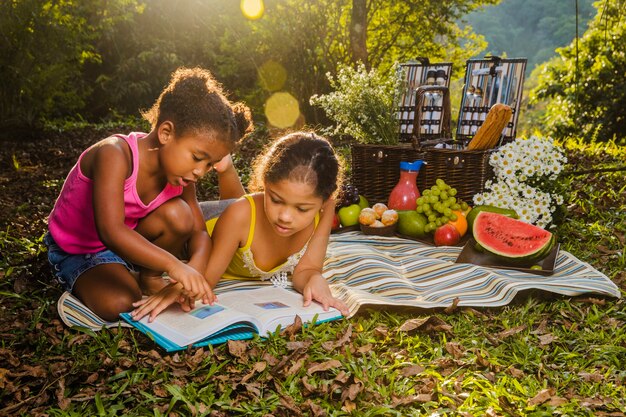 Two girls reading on picnic cloth