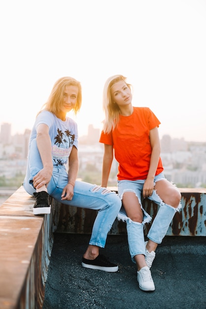 Две девушки, сидящие на крыше