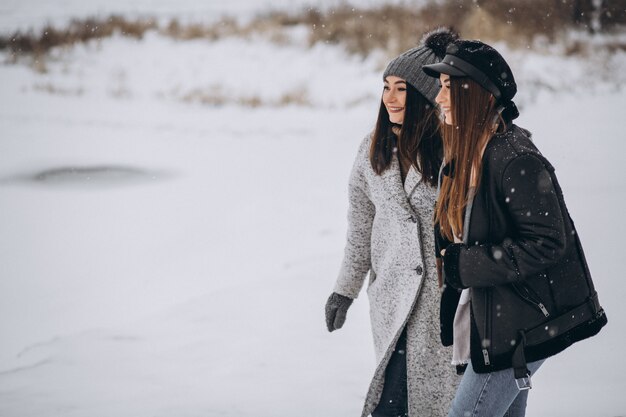 Two girls walking together in a winter park