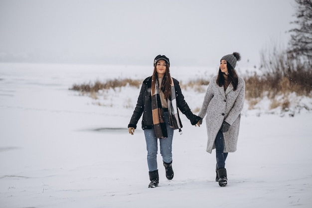 Two girls walking together in a winter park