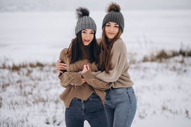 Two girls walking together in a winter park