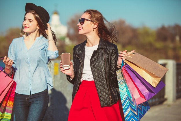 Две девушки гуляют с покупками по улицам города