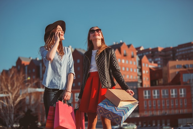 도시의 거리에서 쇼핑을 걷고 두 여자