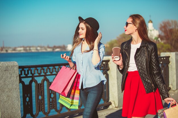 Two girls walking with shopping on city streets