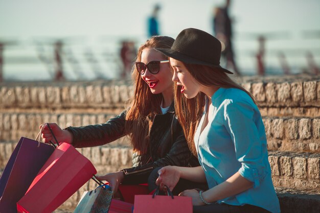 Two girls walking with shopping on city streets