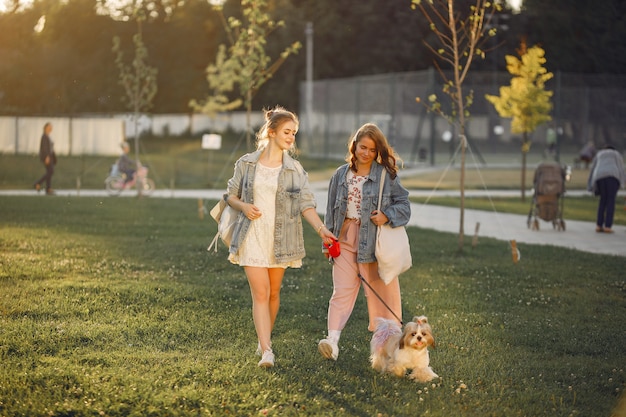 Due ragazze che wallking in un parco con un cagnolino