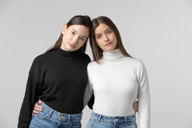 Two girls wearing black and white t-shirt posing in studio
