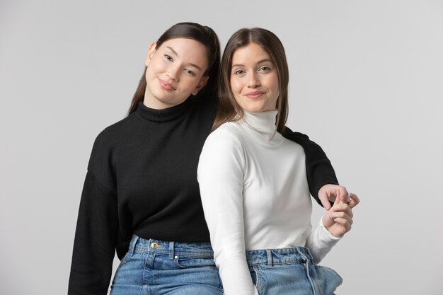 Two girls wearing black and white t-shirt posing in studio