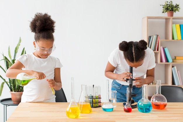 Two girls with safety glasses experimenting with science and potions