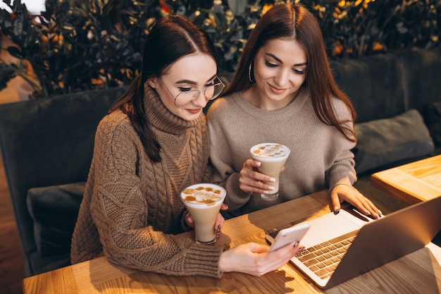 Due ragazze che lavorano su un computer in un caffè