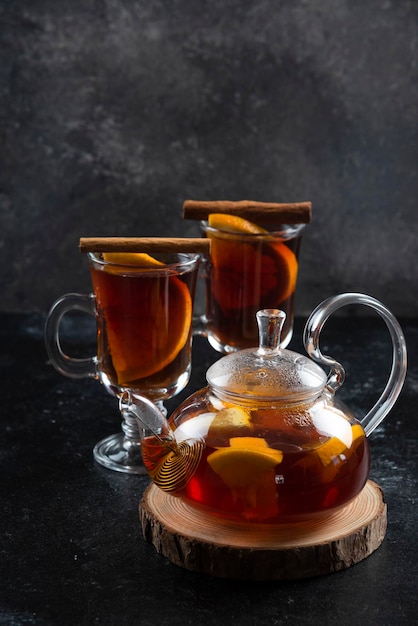Two glass cups with hot tea and cinnamon sticks.