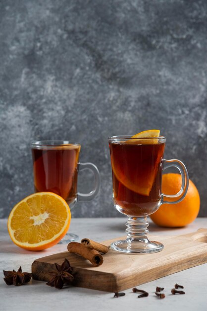 Two glass cups with hot tea and cinnamon sticks.