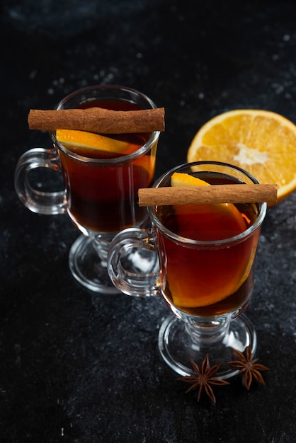 Two glass cups with tasty tea and cinnamon sticks.